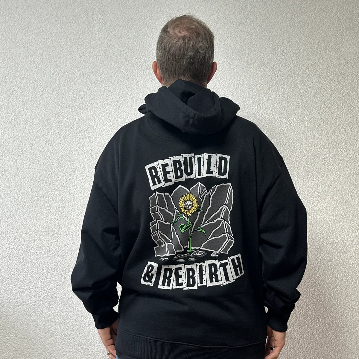 Hoodie Rebuild & Rebirth noir porté par Benoît, fondateur de JaOcCo, coupe oversize taille M, vue de dos